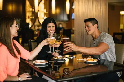 a group of people sitting around a table drinking wine at Rosen Plaza Hotel Orlando Convention Center in Orlando