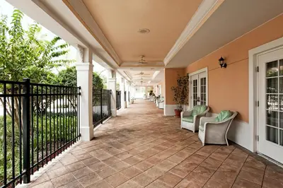 a porch with chairs and a fence at Monumental Hotel Orlando in Orlando