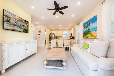 a living room with a white couch and a ceiling fan at Cannon Thunder Cottage With Private Hot Tub Near Disney With Margaritaville Resort & Island H2O Access - 3066Pi in Orlando