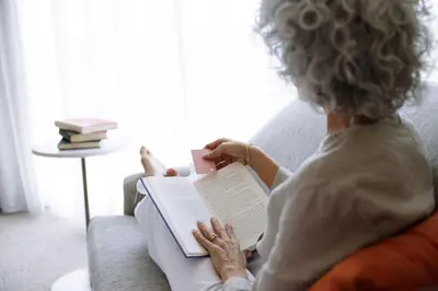 a woman sitting on a couch reading a book at JW Marriott Orlando Bonnet Creek Resort & Spa in Orlando