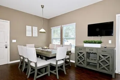 a dining room with a table and chairs and a tv at Amazing townhouse fits 10 in gated community 10 min to Disney! in Kissimmee