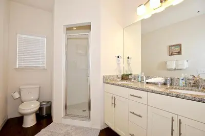 a white bathroom with a toilet and a shower at Amazing townhouse fits 10 in gated community 10 min to Disney! in Kissimmee