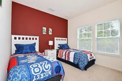 two beds in a bedroom with red walls at Amazing townhouse fits 10 in gated community 10 min to Disney! in Kissimmee