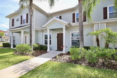 a house with palm trees in front of it at Amazing private townhouse in gated community with amenities Great location, near Disney! in Kissimmee
