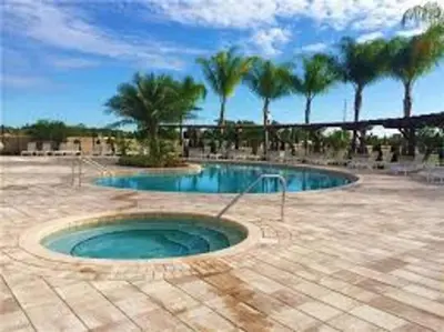 a swimming pool with palm trees in a courtyard at Amazing private townhouse in gated community with amenities Great location, near Disney! in Kissimmee