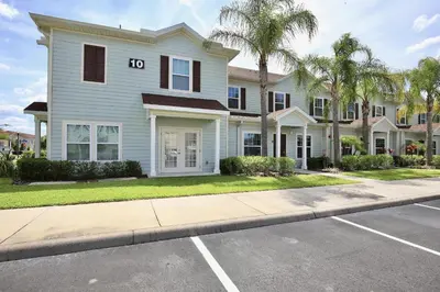 a white house with a sign on it at Amazing private townhouse in gated community with amenities Great location, near Disney! in Kissimmee