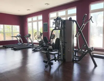 a gym with several tread machines in a room at Fantastic Townhouse in Lux community sleeps 8, 10' to Disney!! in Kissimmee