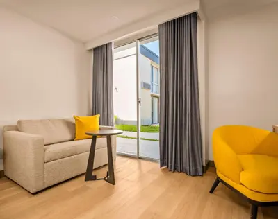 a living room with a couch and a chair and a window at B&B HOTEL Orlando International Drive near Universal - Newly Renovated! in Orlando