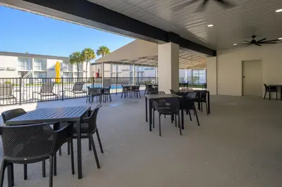 a cafeteria with tables and chairs and a ceiling fan at B&B HOTEL Orlando International Drive near Universal - Newly Renovated! in Orlando