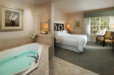 a hotel room with a bed and a bath tub at Sheraton Vistana Resort Villas, Lake Buena Vista Orlando in Orlando