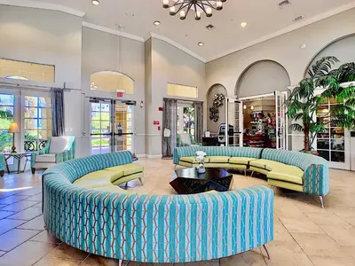 a living room with blue couches and tables at Vista Cay at Epic Universe - Luxury 4 bedroom condo in Orlando