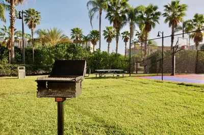 a barbecue grill in a park with palm trees at Vista Cay at Epic Universe - Luxury 3 bedroom Townhouse in Orlando