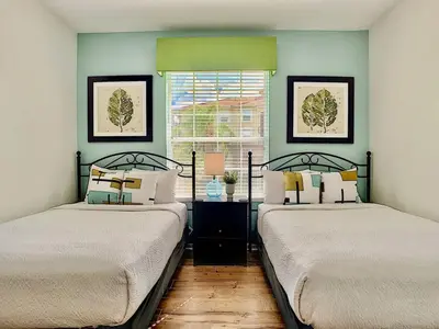 two beds in a room with a window at Vista Cay at Epic Universe - Luxury 4 bedroom condo in Orlando