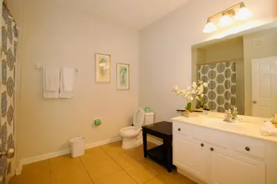 a bathroom with a sink and a toilet and a mirror at Vista Cay at Epic Universe - Standard 2 bedroom condo in Orlando