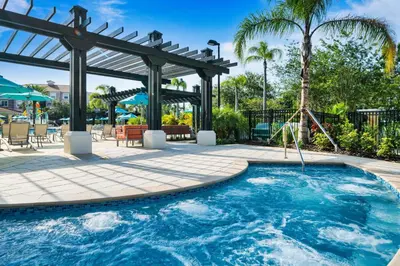 a swimming pool with a pergola and a swing at Vista Cay at Epic Universe - Standard 3 bedroom condo in Orlando