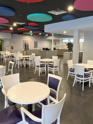 a cafeteria with white tables and white chairs at Grand Hotel Orlando at Universal Blvd - Shuttle to Theme Parks in Orlando