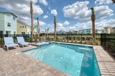 a swimming pool with two chairs and palm trees at Tranquil Ocean Blue Cottage Near Disney With Private Pool & Margaritaville Resort & Island H20 Waterpark Access - 3000Ph in Orlando