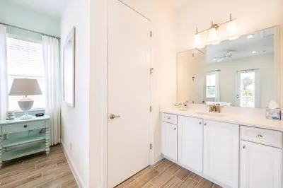 a white bathroom with a sink and a mirror at Sea Breeze Cottage Near Disney With Private Hot Tub & Margaritaville Resort & Island H20 Waterpark Access - 3016Sr in Orlando