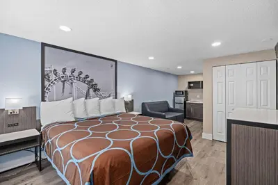 a hotel room with a bed and a desk and a chair at Super 8 by Wyndham Kissimmee-Orlando in Kissimmee