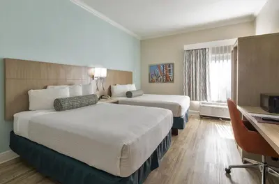 a hotel room with two beds and a desk at Galleria Palms Orlando - Free Theme Park Shuttles in Orlando