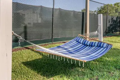 a hammock on the grass next to a fence at Orbit One Vacation Villas in Orlando