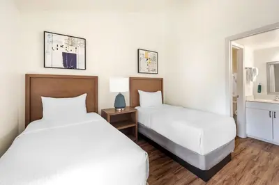 a hotel room with two beds and a bathroom at Bryan's Spanish Cove in Orlando