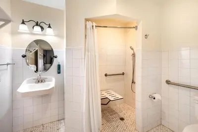 a bathroom with a shower and a sink and a mirror at Bryan's Spanish Cove in Orlando