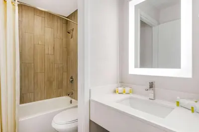 a bathroom with a sink and a toilet and a mirror at Super 8 by Wyndham Orlando Near Florida Mall in Orlando