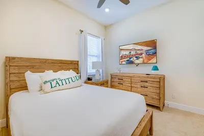 a bedroom with a large bed and a mirror at Sandy White Cottage Near Disney With Private Hot Tub & Margaritaville Resort & Island H20 Waterpark Access - 3001Sp in Orlando