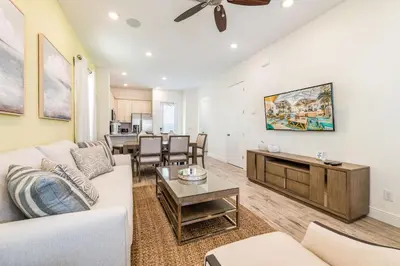 a living room with a couch and a table at Playa Verde Cottage With Private Hot Tub Near Disney With Margaritaville Resort & Island H2O Access - 8028Dr in Orlando