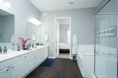 a white bathroom with two sinks and a shower at 2-403 Your Vista Cay Condo in Orlando