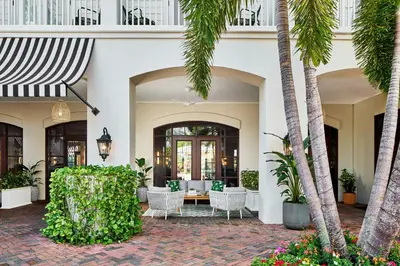 a lobby with palm trees and a table and chairs at The Inn at Celebration, Autograph Collection in Orlando
