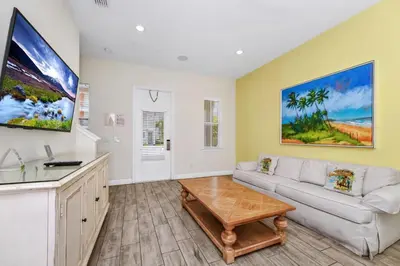 a living room with a couch and a table at Teenie Bikini Cottage With Private Hot Tub Near Disney With Margaritaville Resort & Island H2O Access - 3071Kl in Orlando
