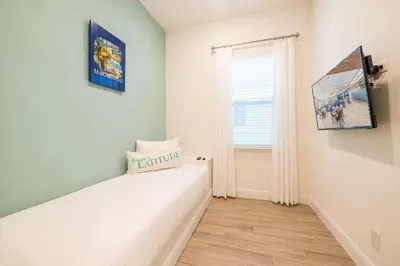 a bedroom with a bed and a window at Another Day In Paradise Cottage With Private Hot Tub Near Disney With Margaritaville Resort & Island H2O Access - 8024Dr in Orlando