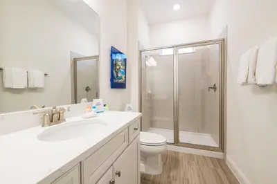 a white bathroom with a toilet and a shower at Another Day In Paradise Cottage With Private Hot Tub Near Disney With Margaritaville Resort & Island H2O Access - 8024Dr in Orlando