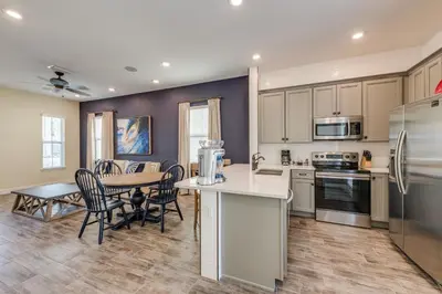 a kitchen and dining room with a table and chairs at Breezy Cottage With Hot Tub Near Disney With Margaritaville Resort & Island H2O Access - 8069Dr in Orlando