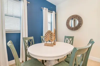 a dining room with a white table and chairs at Cozy Cottage With Hot Tub Near Disney With Margaritaville Resort & Island H2O Access - 8056Dr in Orlando