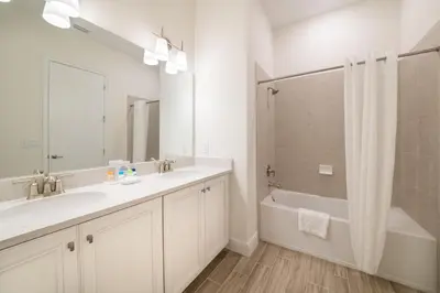 a bathroom with a sink and a tub and a mirror at Paradise Cottage With Private Pool Near Disney And Margaritaville Resort & Island H20 Waterpark Access - 7989Su in Orlando