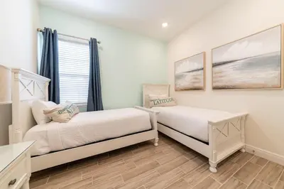 two beds in a room with a window at Waterfront Cottage With Private Pool Near Disney And Margaritaville Resort & Island H20 Access - 7985Su in Orlando