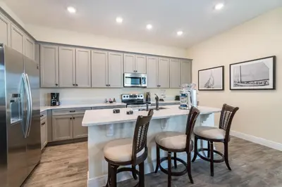 a kitchen with a large island with four chairs at Bon Voyage Cottage With Private Pool Near Disney With Margaritaville Resort & Island H2O Access - 8045Su in Orlando