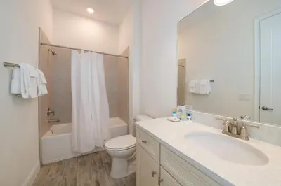 a white bathroom with a sink and a toilet at Livin In Paradise Cottage With Private Hot Tub Near Disney With Margaritaville Resort & Island H2O Access - 8076Dr in Orlando