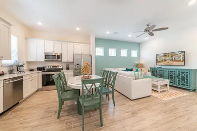 a kitchen and living room with a table and chairs at We Be Jammin Cottage With Private Hot Tub Near Disney With Margaritaville Resort & Island H2O Access - 8020Dr in Orlando