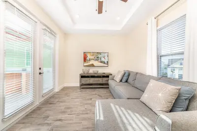 a living room with a couch and windows at Fun In The Sun Cottage With Private Pool Near Disney With Margaritaville Resort & Island H2O Access - 8052Sh in Orlando