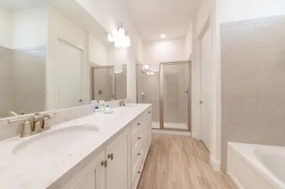 a white bathroom with two sinks and a tub and a shower at Ocean Waves Cottage With Private Pool Near Disney With Margaritaville Resort & Island H2O Access - 8001Su in Orlando