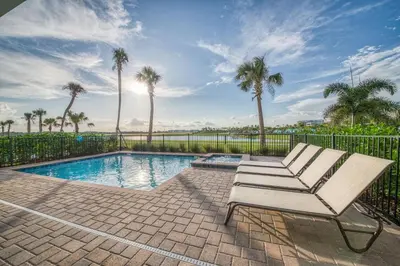 a white chair sitting next to a swimming pool at It's All Fin & Games Cottage With Private Pool Near Disney & Margaritaville Resort & Island H20 Waterpark Access - 3090Ph in Orlando