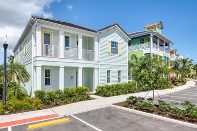 a white house with a balcony on a street at It's All Fin & Games Cottage With Private Pool Near Disney & Margaritaville Resort & Island H20 Waterpark Access - 3090Ph in Orlando