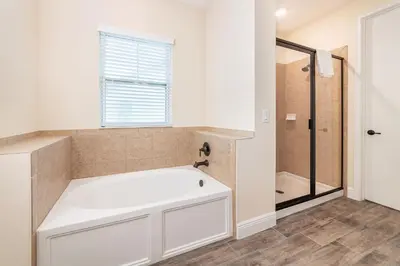 a bathroom with a white tub and a shower at High Tide Cottage With Private Pool Near Disney With Margaritaville Resort & Island H2O Access - 8053Su in Orlando