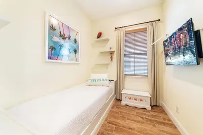 a small room with a bed and a window at Fiesta Siesta Cottage With Hot Tub Near Disney With Margaritaville Resort & Island H2O Access - 8068Dr in Orlando