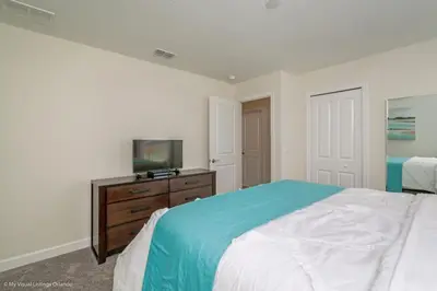 a bedroom with a bed and a tv on a dresser at 891Pbeach Amazing Champions Gate 8 Bedroom 5 Bed Villa in Orlando