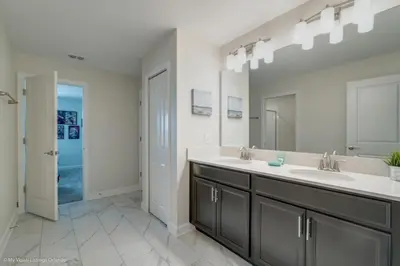a bathroom with two sinks and a large mirror at 891Pbeach Amazing Champions Gate 8 Bedroom 5 Bed Villa in Orlando